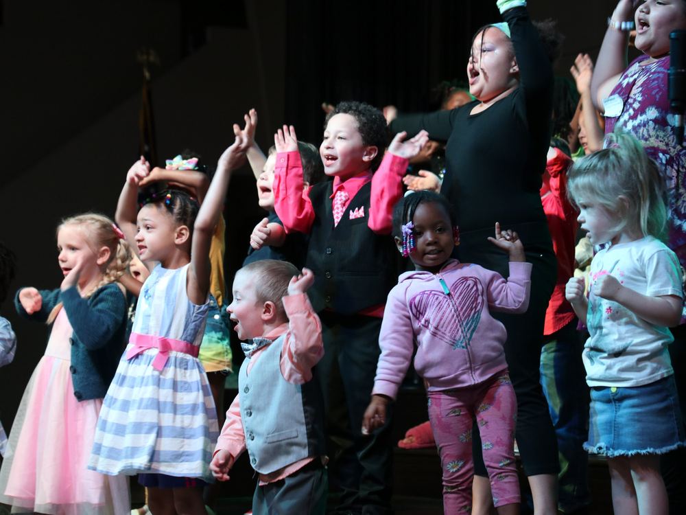 Kids singing and celebrating on stage
